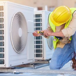 commercial hvac technician working on an air handler on a building's roof