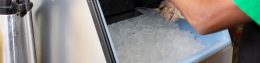 man scooping ice out of a commercial ice machine