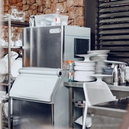 commercial ice machine surrounded by clean dishes in a commercial kitchen